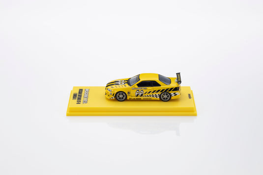 NISSAN SKYLINE GT-R (R34) MOONEYES 1 AVEC LED 2026 + SYSTÈME DE SOCLE LED MOTN NOIR 2025 KYOSHO 1:64