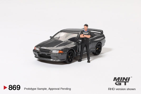 Nissan SKYLINE GT-R (R32) NISMO NISMO GUNMETAL AVEC FIGURINE TSUGIO MATSUDA 1992 (RHD) MINI GT 1:64